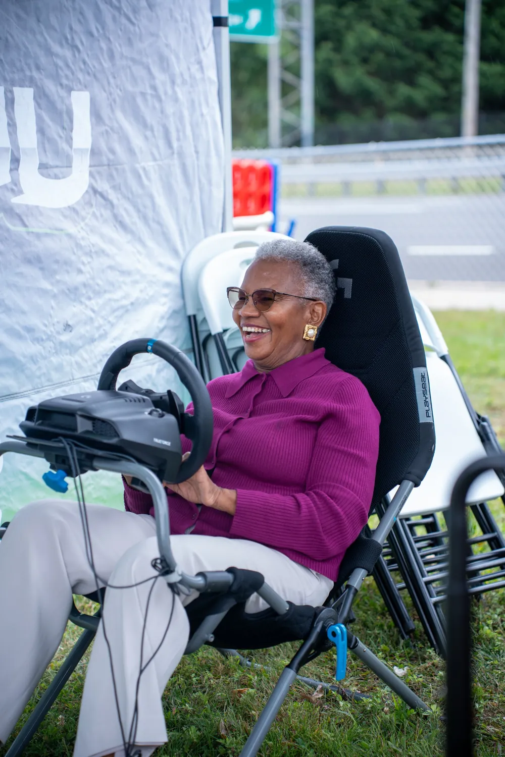 Guest laughing on the racing simulator at an NYC community event